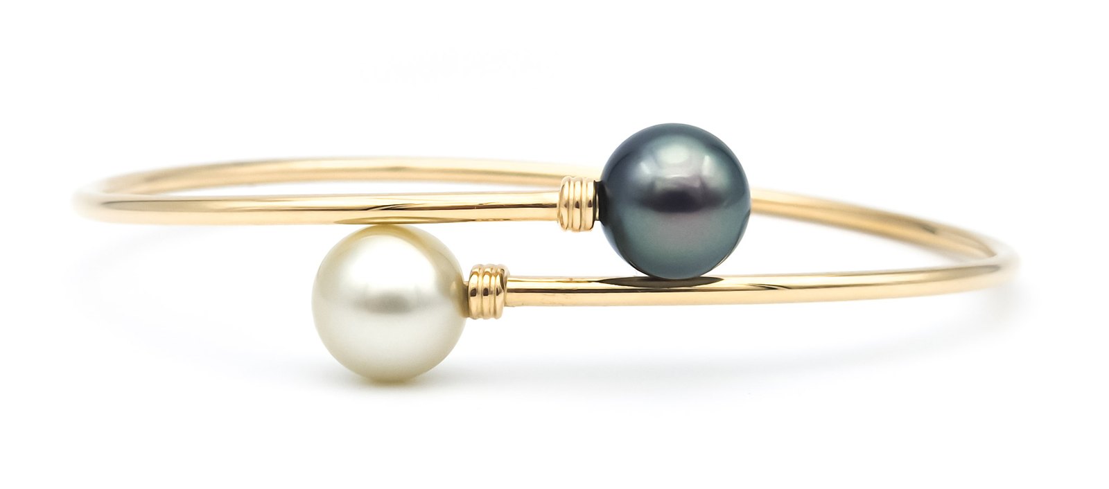 Bracelet jonc en or jaune serti d'une perle de Tahiti et d'une perle claire
